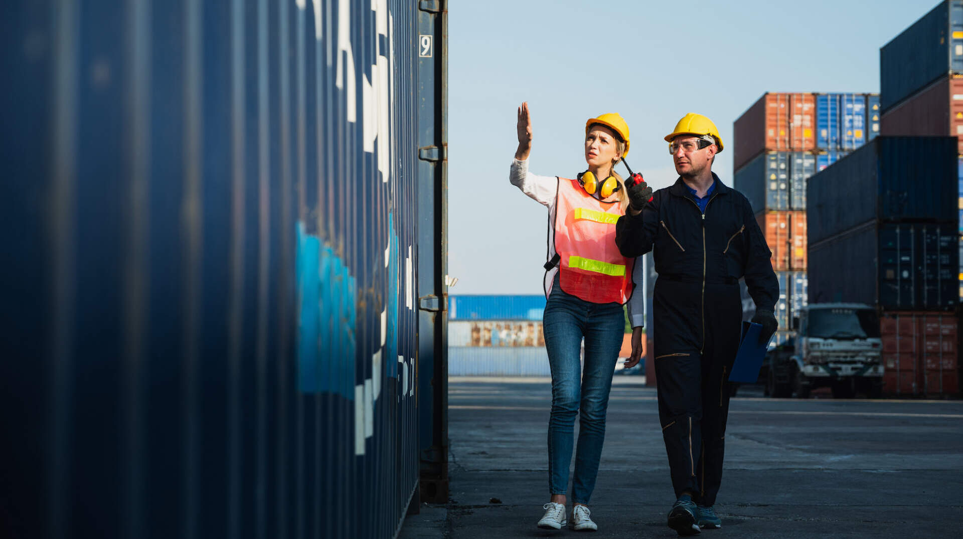 Two foreman man & woman worker working checking at Container cargo harbor to loading containers. Dock male and female staff business Logistics import export shipping concept.