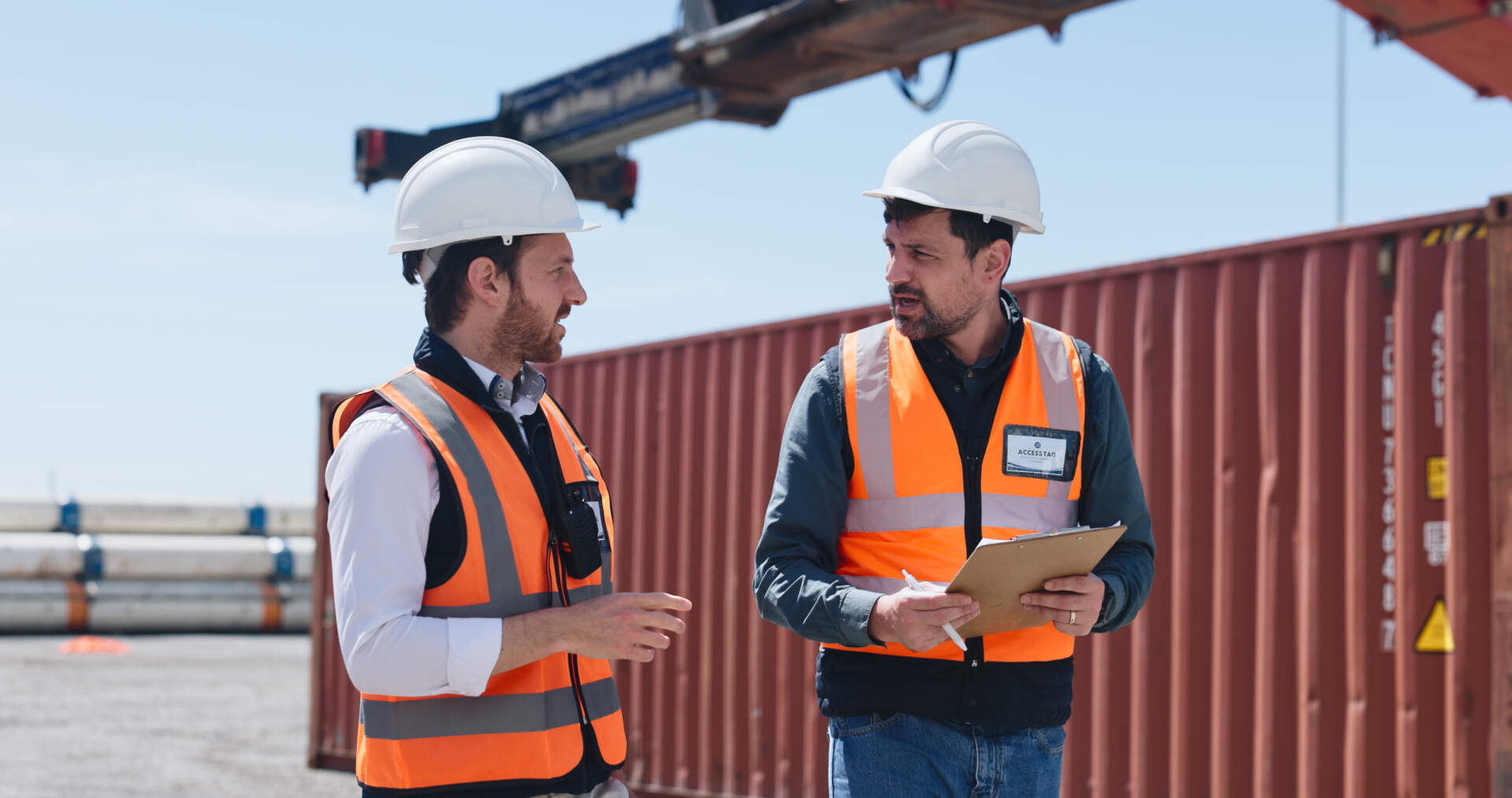 Shipping, team and discussion at container yard for supply chain, inspection and checklist. Men, workers and planning shipment at dock for freight, logistics clipboard or export cargo in industry